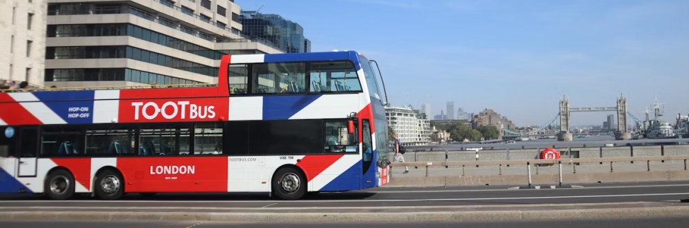A red Tootbus sightseeing bus on a London street.