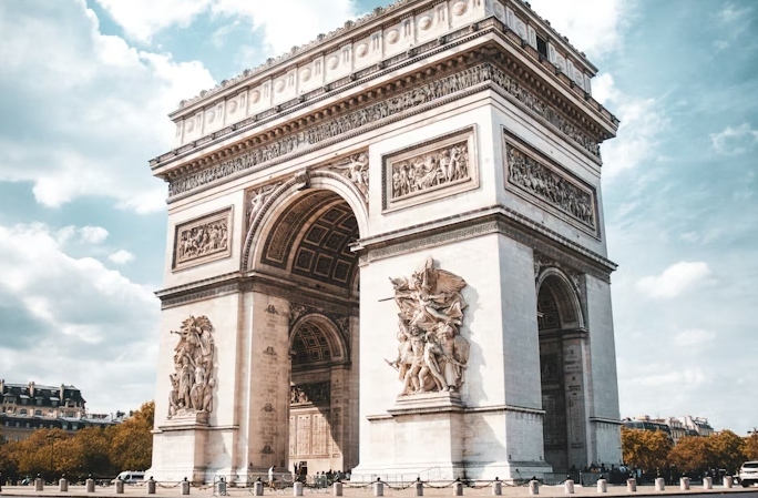 The Arc de Triomphe under a bright sky in Paris.