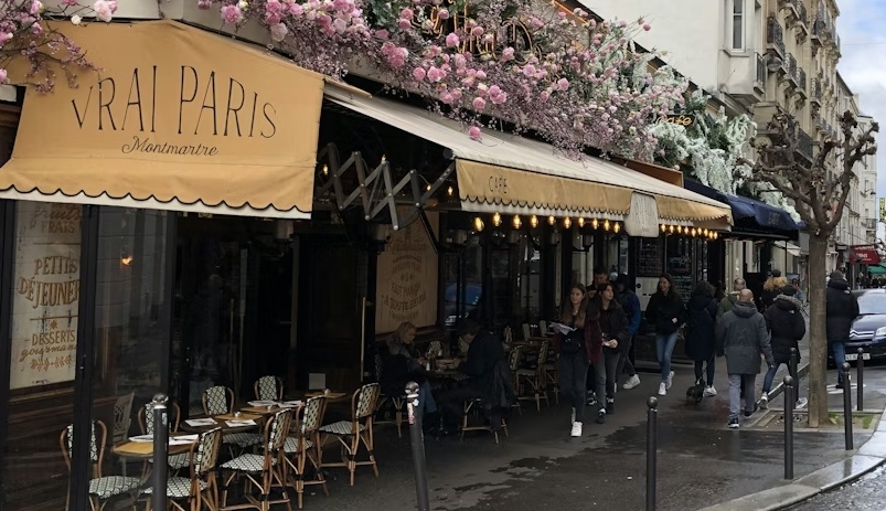 A flower-covered cafe front along a Montmartre street.