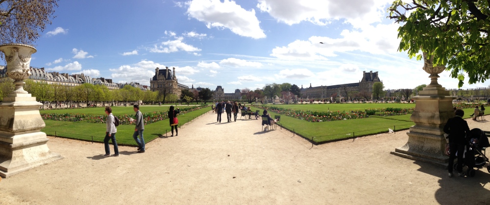 Visitors walking through the Tuileries Garden on a sunny day in Paris.