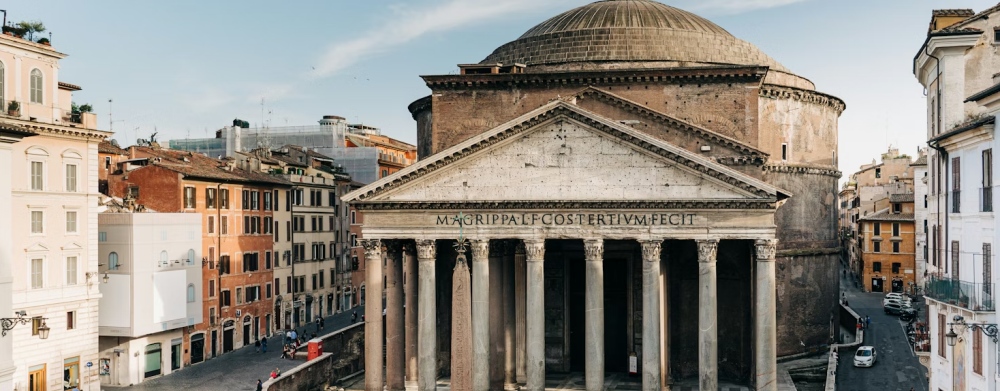 The Pantheon facade and dome above surrounding buildings in Rome.