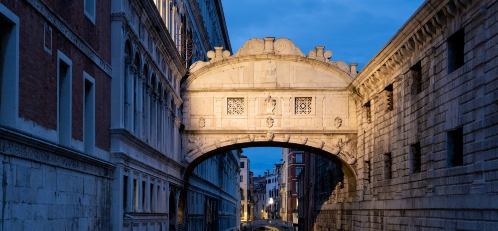 The Bridge of Sighs lit at dusk in Venice.
