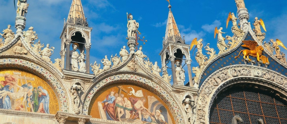 Golden mosaics and spires on the facade of St. Mark's Basilica.