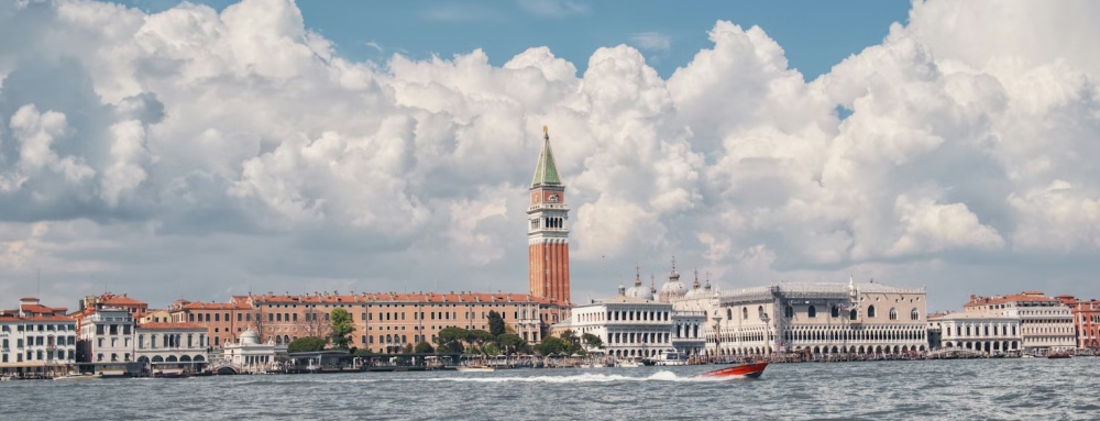 The Venice waterfront with St. Mark's Campanile under huge clouds.